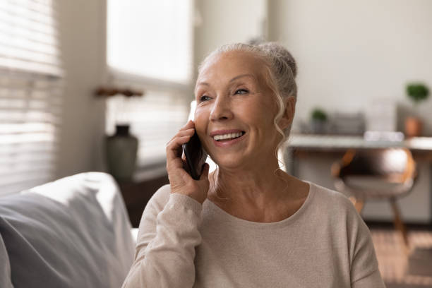 istock Excited mature woman making call using cell enjoy good conversation 1319103376