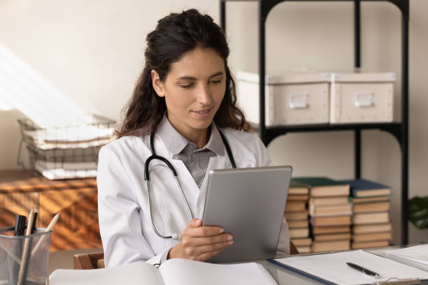 Young woman medical worker use pad study information on website
