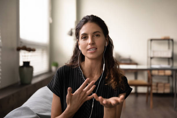 Inspired female teacher in headphones meet students online give class Video conversation. Inspired latin female teacher in headphones meet students online look at camera give virtual class. Portrait of confident young saleswoman wear headset consult client by videocall looking at camera stock pictures, royalty-free photos & images