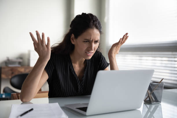 mad young woman worker losing job result on broken pc - frustração imagens e fotografias de stock