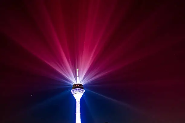 Duesseldorf, Rhine Tower with laser beams of the Rhine Comet during Telekom 2021 5G advertising, Rhine, old town, state parliament at the blue hour