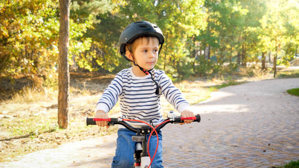 istock Little toddler boy riding bicycle on path at park 1319112435