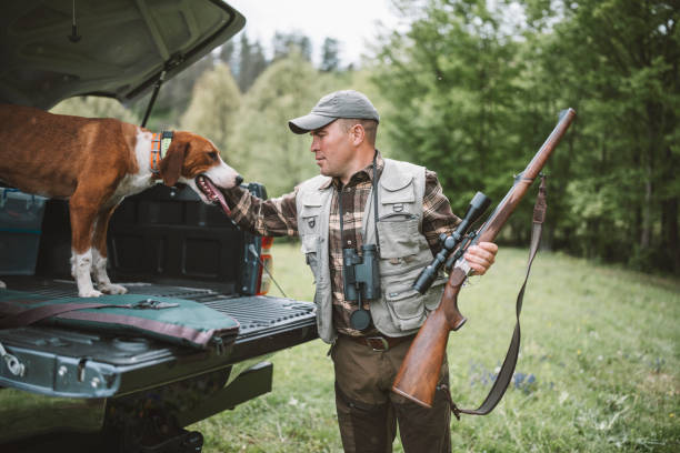 cacciatore e cane si preparano per la sessione di caccia. - rifle hunting gun aiming foto e immagini stock