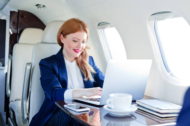 istock Businesswoman using laptop in private airplane 1319118424