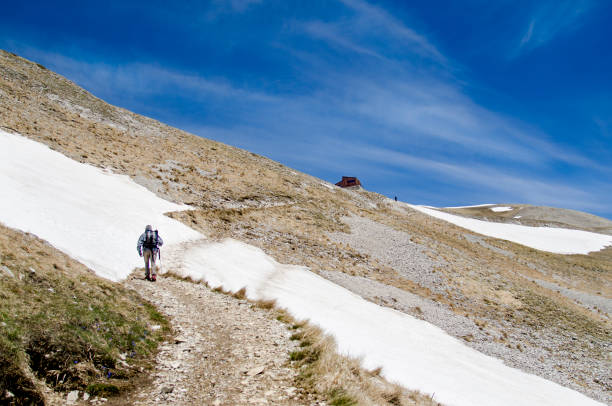 Hiker on Monte Vettore Monti Sibillini, Italy: Hiker approaching the Zilioli refuge, riding between Monte Vettore and Monte Redentore. sports photography stock pictures, royalty-free photos & images