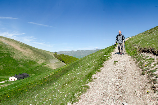 Asian Indian woman hiking alone in Welsh hills towards Pen Y Fan, Brecon Beacons, Wales, UK