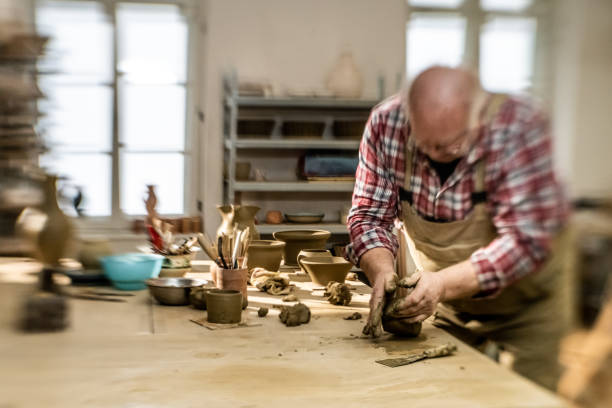istock Senior master craftsman kneading a lump of clay 1319131602
