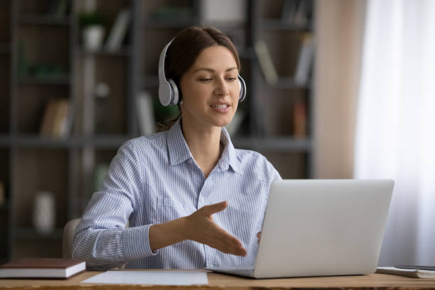 istock Young lady in wireless earphones speak by computer screen 1319136441