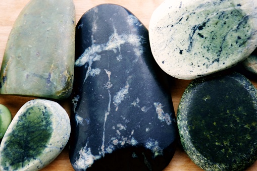 Close-up on a group of hand smoothed Pounamu Greenstone rocks.
