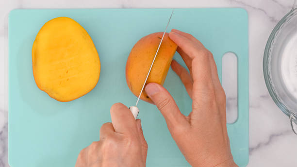 istock Woman hands cutting fresh ripe mango, close up view from above 1319153453