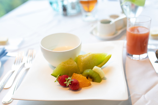 A plate of fresh fruit on a plate served at a high end restaurant.