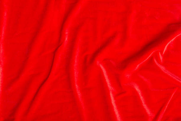 istock Colored red textile satin fabric folded in folds and waves with highlights and texture 1319156640