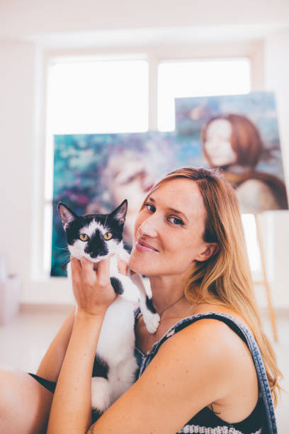 istock Portrait of a professional painter taking a break and playing with her cat 1319162749