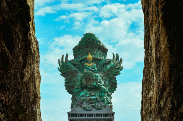 A view of Garuda Wisnu Kencana statue between the limestone cliffs.