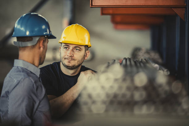 istock Manual worker talking to quality control inspector in aluminum mill. 1319167362