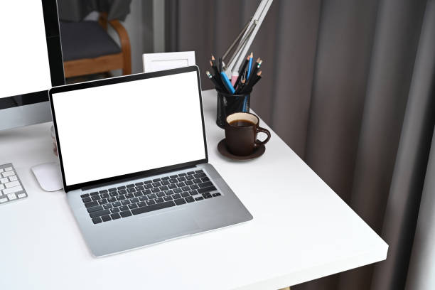istock Computer laptop with blank screen on white desk in home office. 1319168338