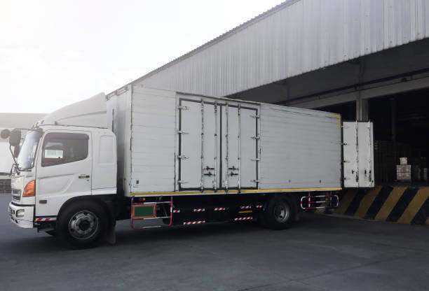 istock Cargo Container Truck Parked Loading at Dock Warehouse. Cargo Shipment. Industry Freight Truck Transportation. Shipping Warehouse Logistics. 1319169537