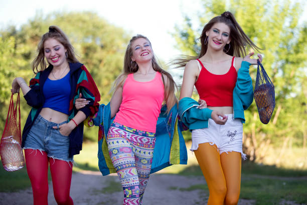 아홉 명의 스타일로 옷을 입은 세 명의 아름다운 시골 소녀가 길을 따라 걷고 있습니다. - fashion fashion model 1980s style women 뉴스 사진 이미지