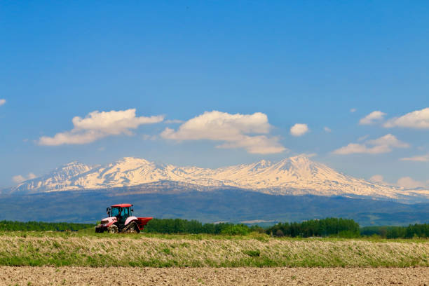 paysage avec daisetsuzan et un tracteur - parc national de daisetsuzan photos et images de collection