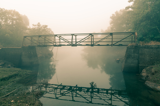 A broken bridge with a few wooden planks spaced out at a few feet to walk across