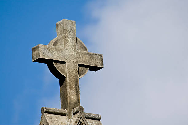 istock Stone Cross Against Blue and White Sky 131918089