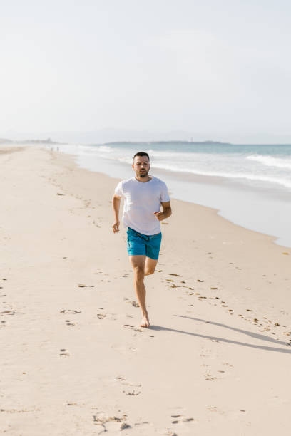 istock Young man running on the beach 1319181103