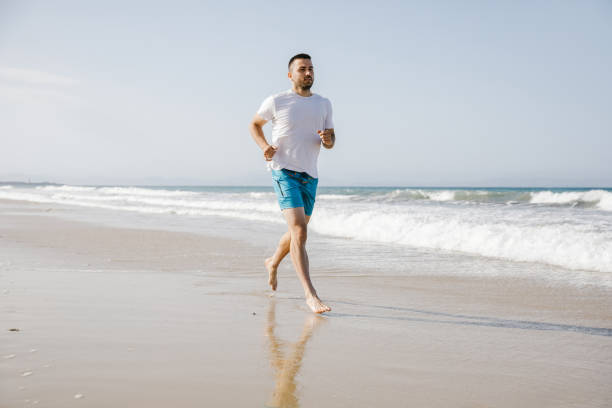 istock Young man running on the beach 1319181165