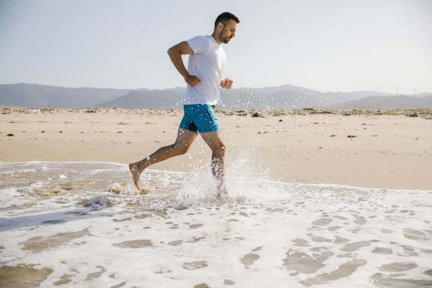 istock Young man running on the beach 1319181415