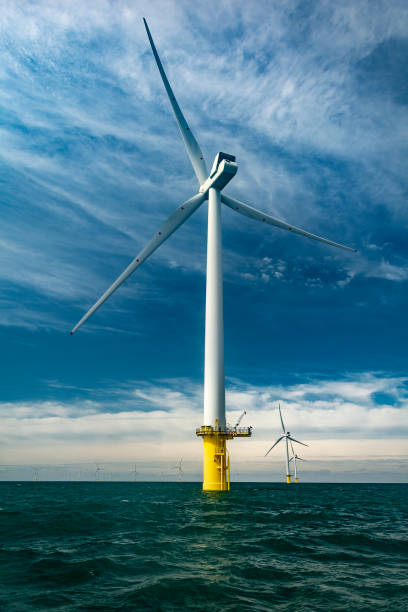 Offshore wind turbine for sustainable energy production View of one of the huge turbines off the coast of Sussex offshore wind farm stock pictures, royalty-free photos & images