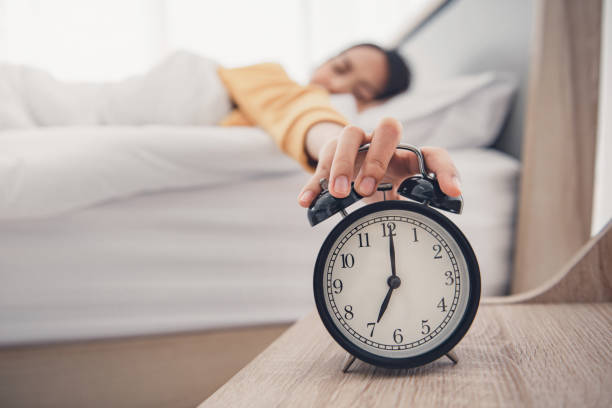 Close-up Hand turns off the alarm clock waking up at morning. Close-up Hand turns off the alarm clock waking up at morning. oversleeping stock pictures, royalty-free photos & images