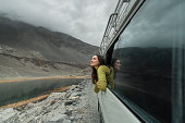 Woman looking at mountains of Northern Pakistan from window in the van