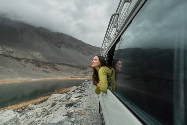 Woman looking at mountains of Northern Pakistan from window in the van Young Caucasian woman looking at mountains of Northern Pakistan from window in the van himalayas photos stock pictures, royalty-free photos & images