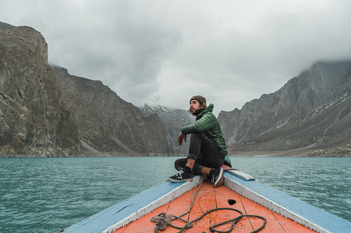 Young Caucasian man travel on the boat on Attabad lake in Pakistan