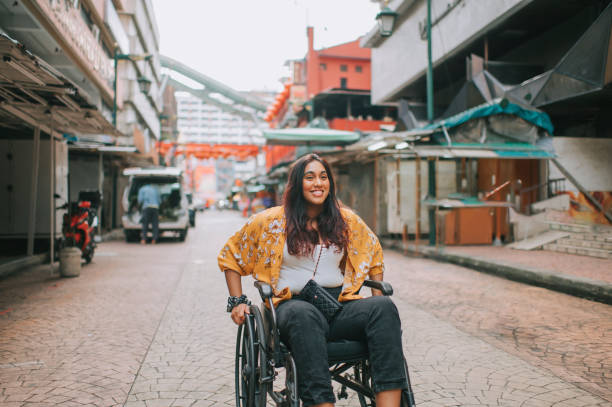istock asian indian beautiful woman with disability using wheelchair exploring downtown district in kuala lumpur 1319190856