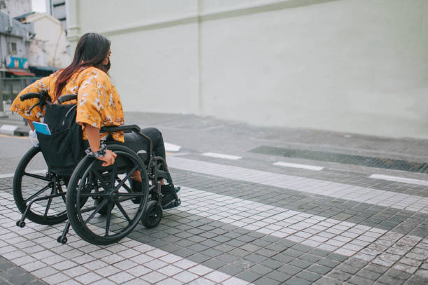 istock side view asian indian beautiful woman with disability using wheelchair zebra crossing crossing road in the city 1319190874