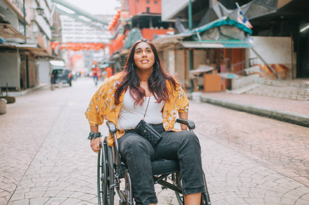 istock asian indian beautiful woman with disability using wheelchair exploring downtown district in kuala lumpur 1319190880