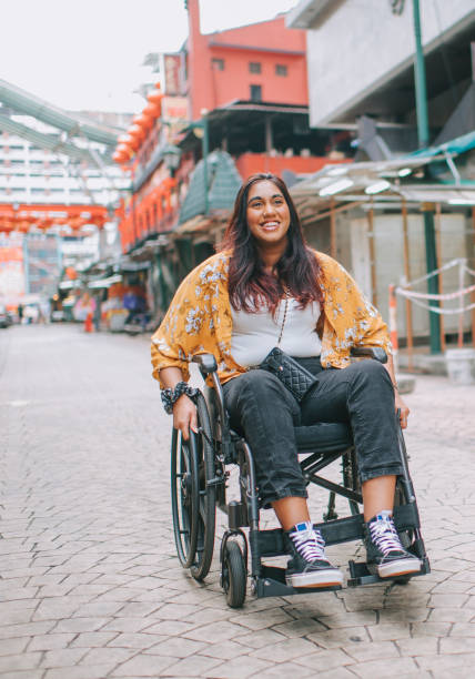 istock asian indian beautiful woman with disability using wheelchair exploring downtown district in kuala lumpur 1319190903