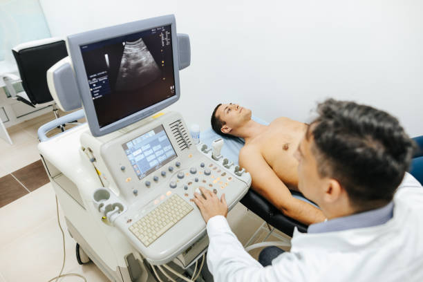 Young male patient having ultrasound examination of abdomen in medical clinic Young male patient lying on bed and having ultrasound examination of abdomen in medical clinic aorta photos stock pictures, royalty-free photos & images