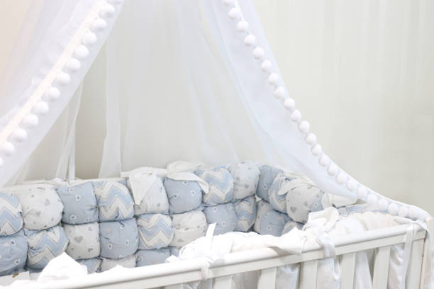 istock Empty baby cot with beautiful blue textiles. Canopy and white crib. 1319194322