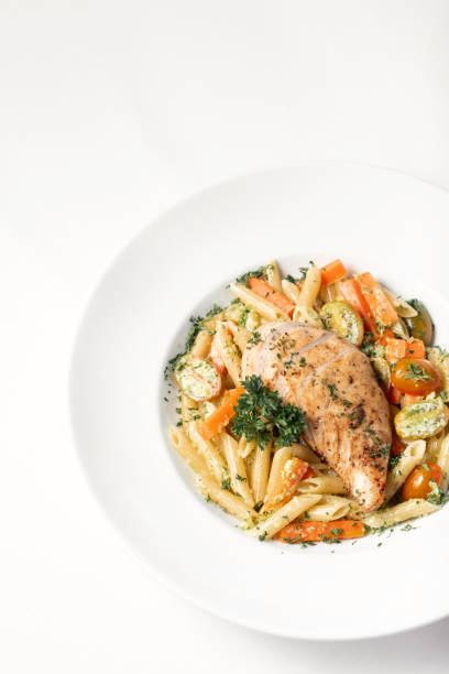 istock fried chicken breast with penne and saute vegetables pasta dish on white background 1319194402