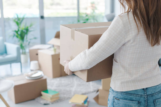 istock Woman carrying boxes in her new apartment 1319195716