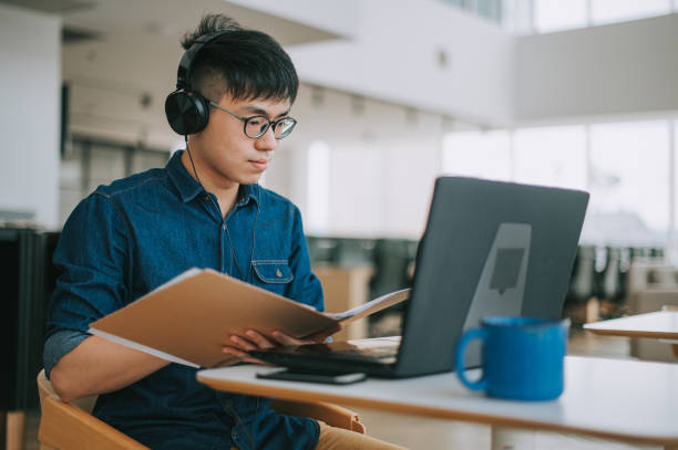 istock asian chinese young man studying using laptop at cafe 1319197207
