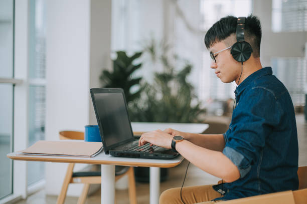 istock asian chinese young man studying using laptop at cafe 1319197217