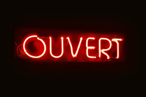 Close-up on a red neon light shaped into the  French word 