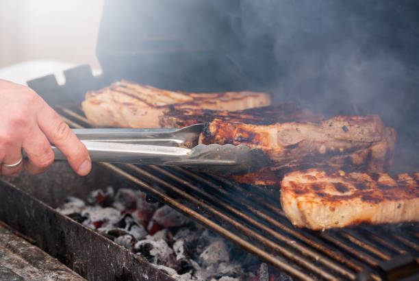 istock grilling steaks on flaming grill. shot with selective focus 1319198898