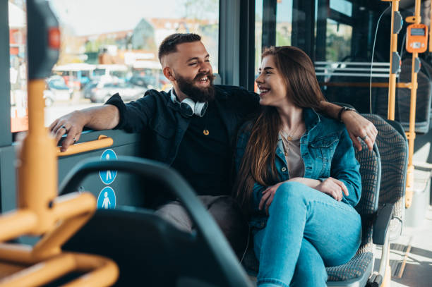 istock Couple sitting in a bus while talking and flirting 1319200296
