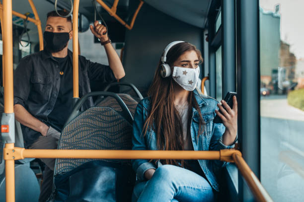 istock Woman wearing protective mask and using a smartphone while riding a bus 1319200297