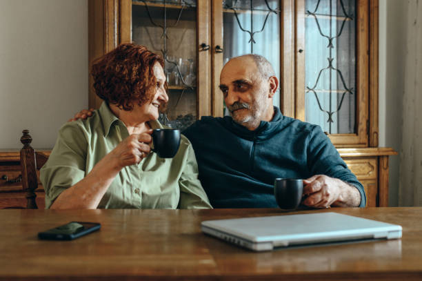 istock Senior couple drinking coffee at home 1319200301