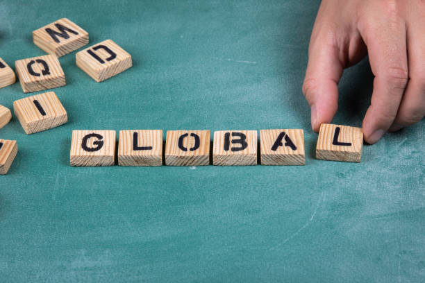 istock GLOBAL. Wooden alphabet letters on a green blackboard background 1319201525