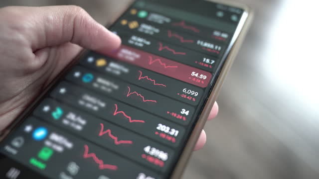 Checking stock market or cryptocurrency data on mobile phone.